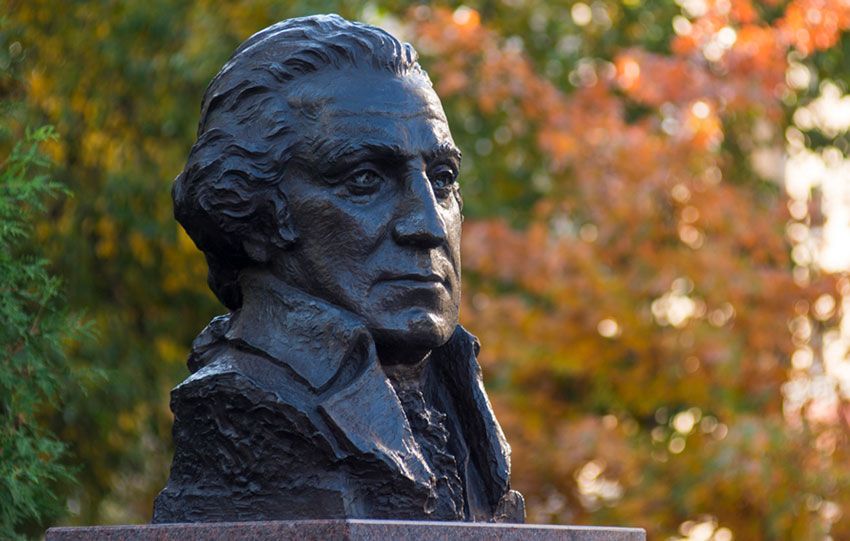 Bust of George Washington in front of autumn foliage