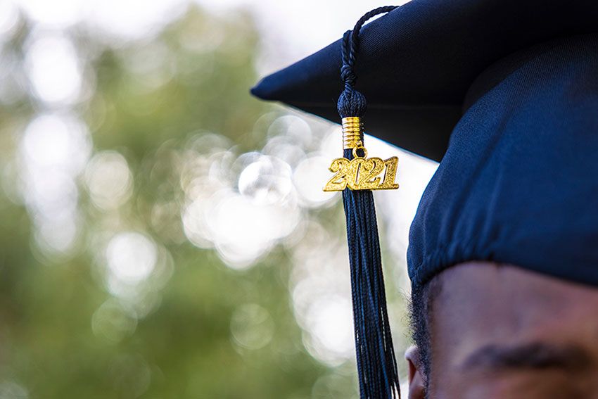 A graduate wearing a 2021 tassle on their cap