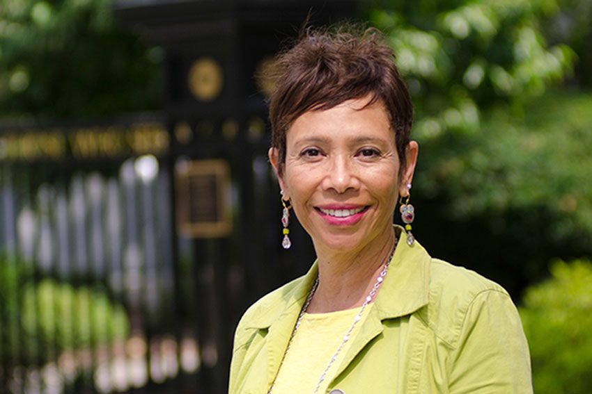 Dr. Yolanda Haywood standing for a portrait in front of a gate