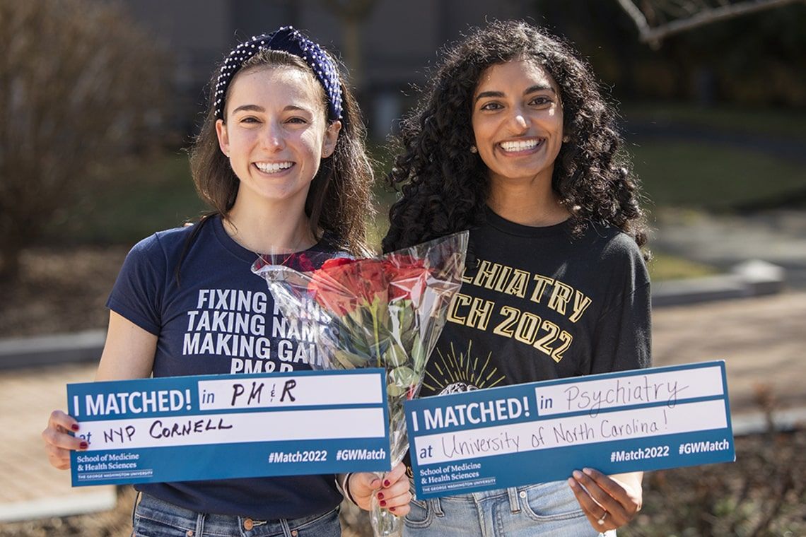 Two medical students pose with their match envelopes