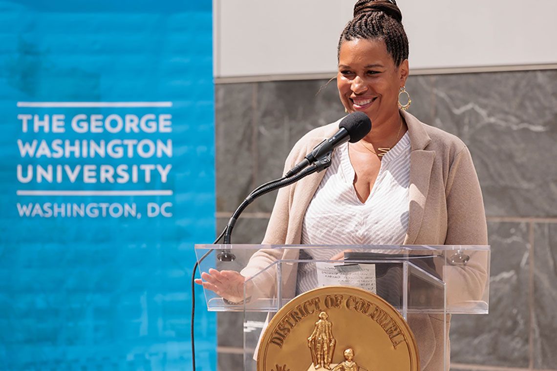 D.C. Mayor Muriel Bowser standing at a podium at GW
