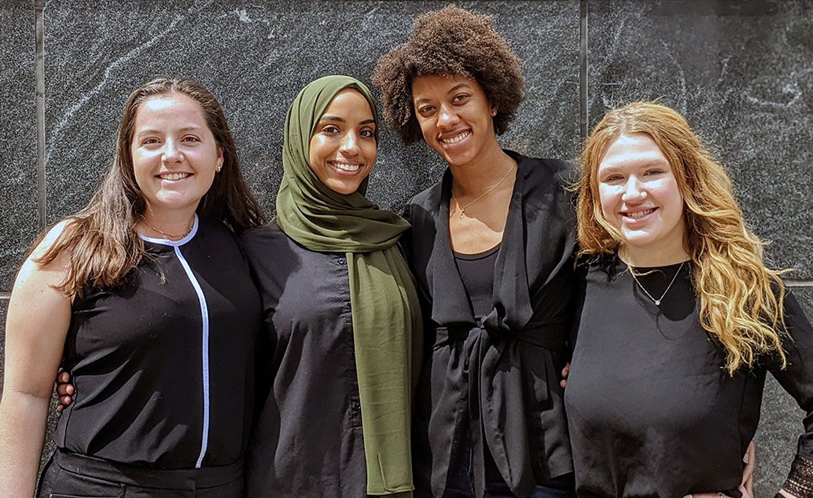 From left, PA students and Pap Smear Project members Laura Tiffany, Fatima Elgarguri, Alana Herran, and Abigail King stand in front of a granite wall