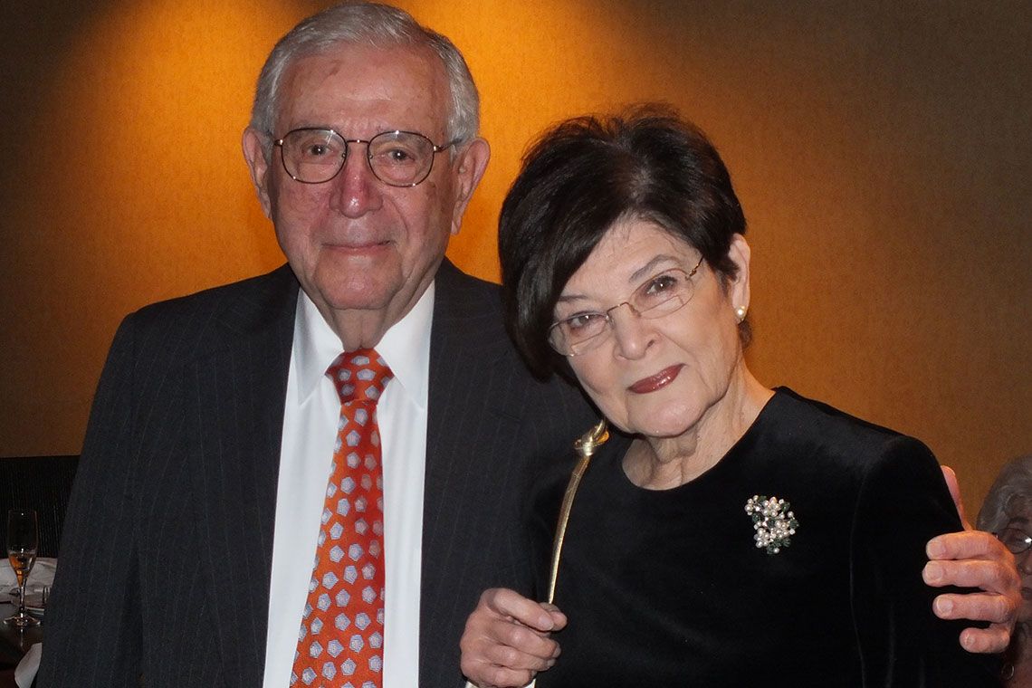 Seymour and Ruth Perlin standing together against an orange wall