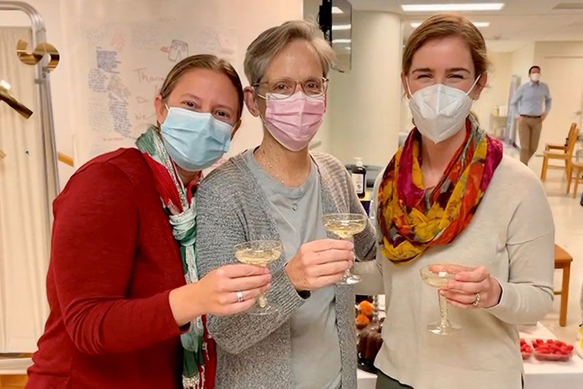 Erin Wentzell, Margaret M. Plack, and Megan Barker stand together holding glasses of wine