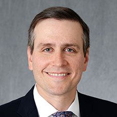 Jonathan Silverberg smiling in a suit