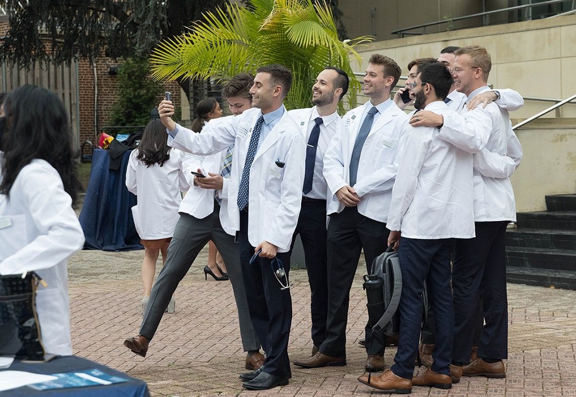 Students take a group selfie together following the 2021 white coat ceremony