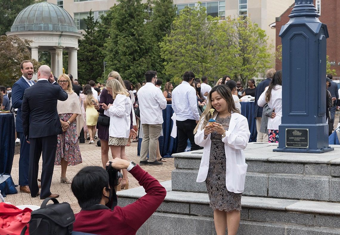 A student poses with a cupcake after the 2021 white coat ceremony