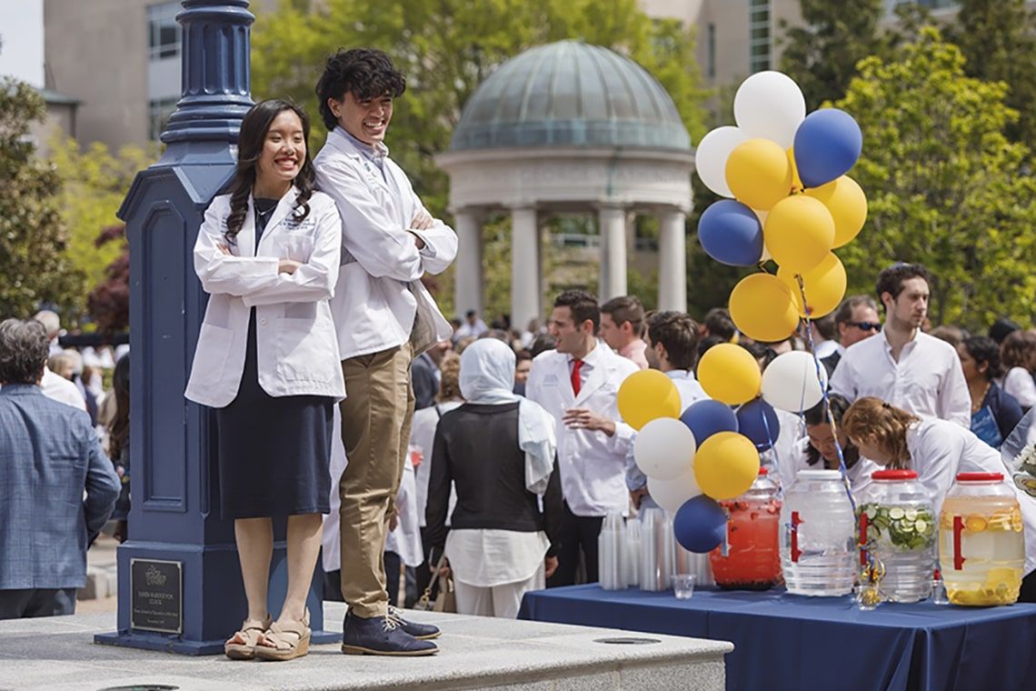 Two students pose against a lamppost outside after the class of 2024 White Coat ceremony