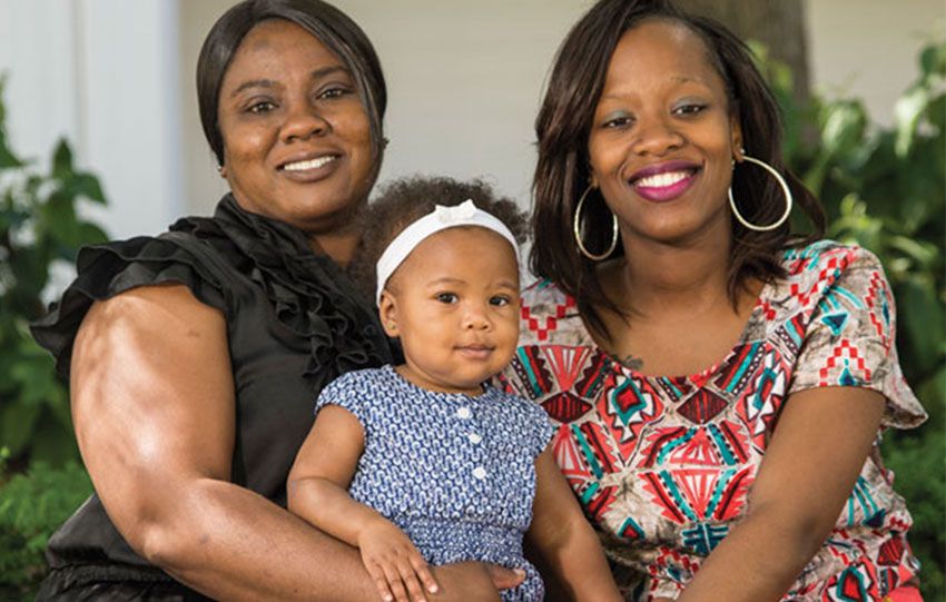 Danette Cunningham sitting with a child and a family member