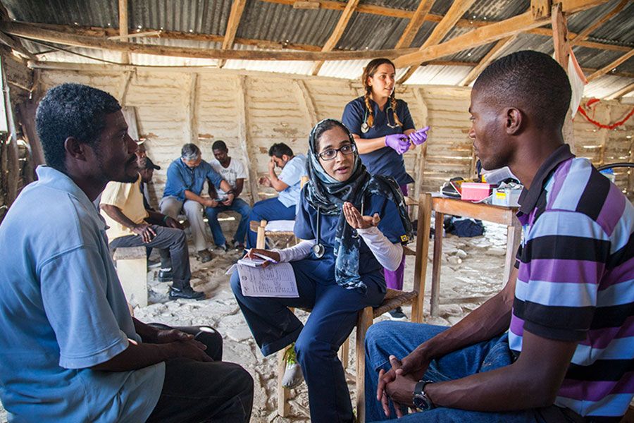 A volunteer with IMP talks with Haitian patients in a clinic