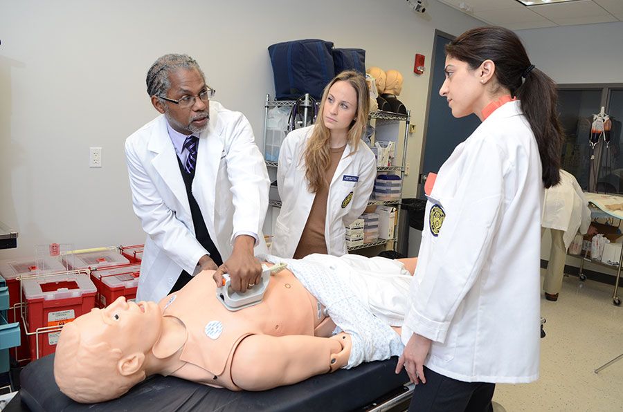 Dr. Howard Straker gives a medical demonstration to students using a dummy