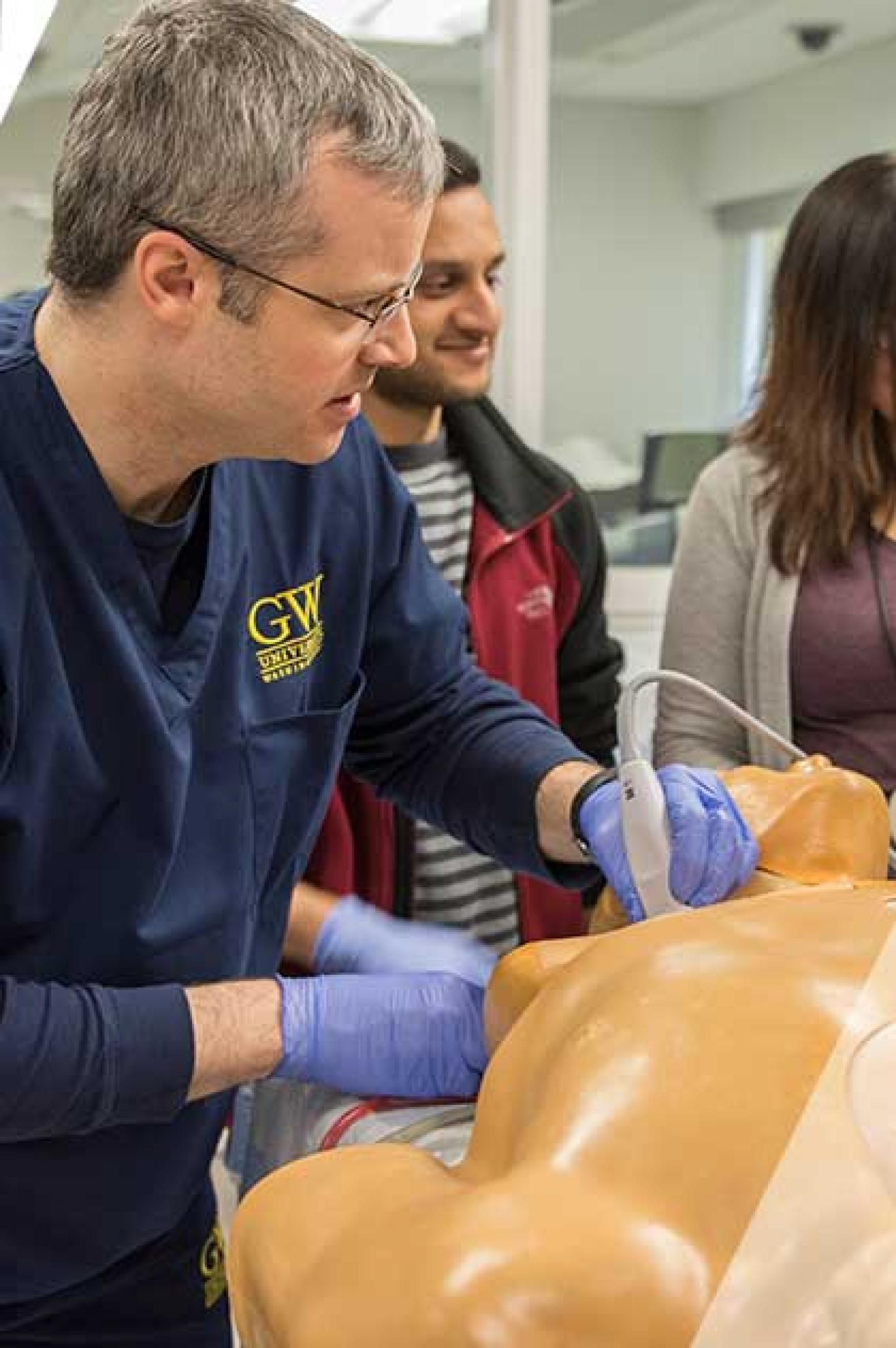 A man practices on a patient manikin