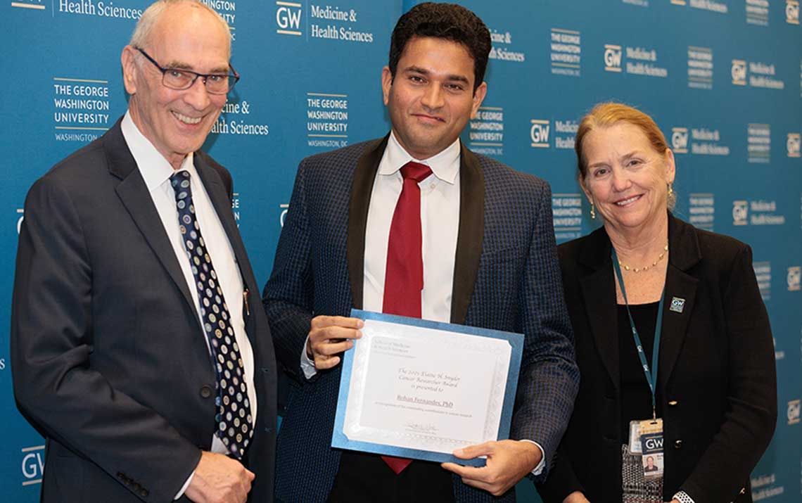 2021 Elaine Snyder Cancer Research Award winner Rohan Fernandes (center) with Dean Robert Miller (left) and Dean Barbara Bass (right)