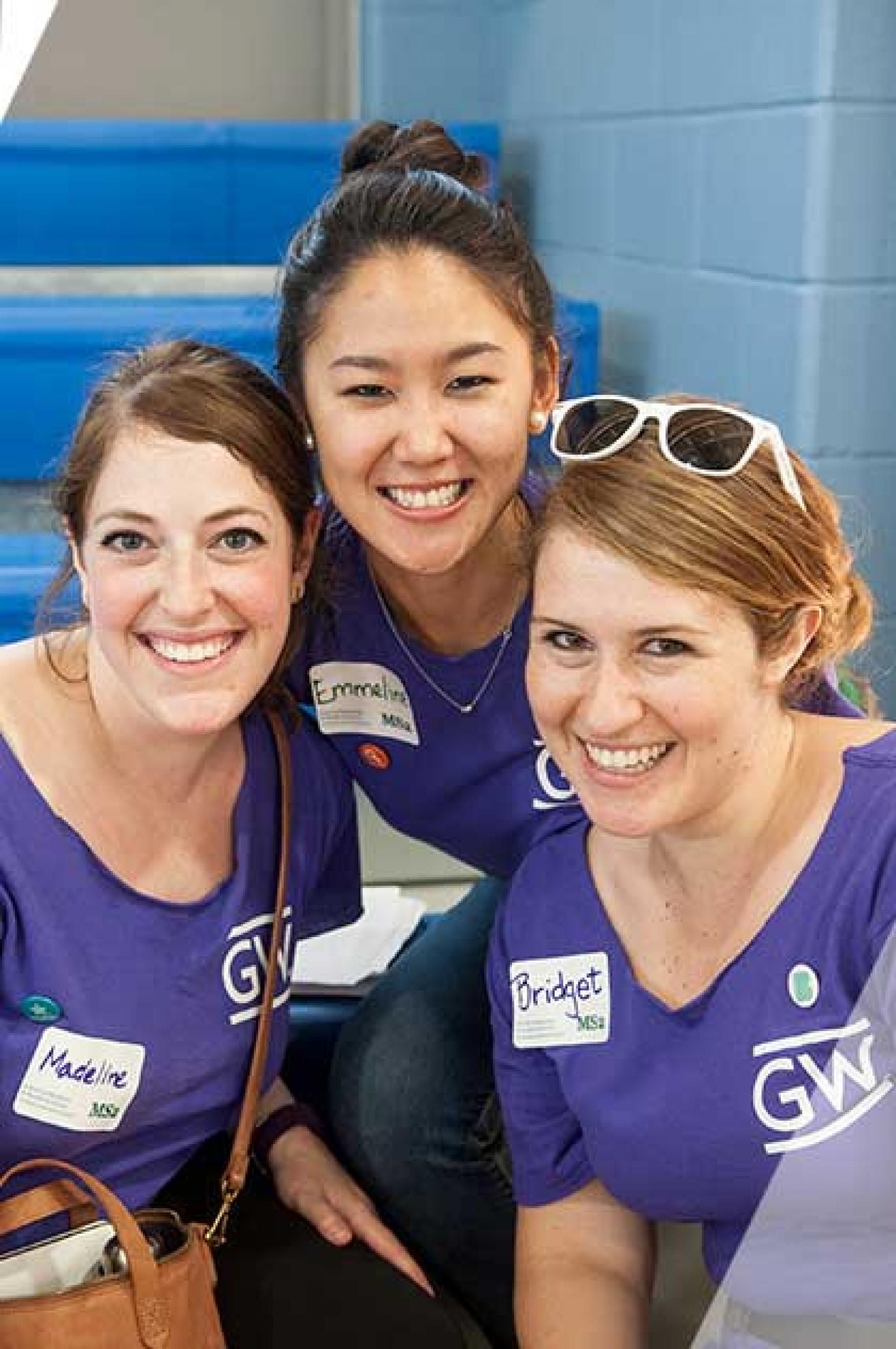 Three female students pose for a photo in a stairwell