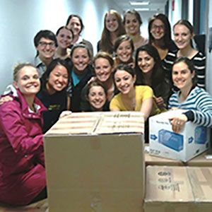 Students posing around packed boxes