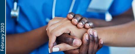 A medical worker grasping another person's hand