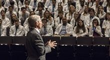 Dr. Anthony Facui speaks to a crowd of med students