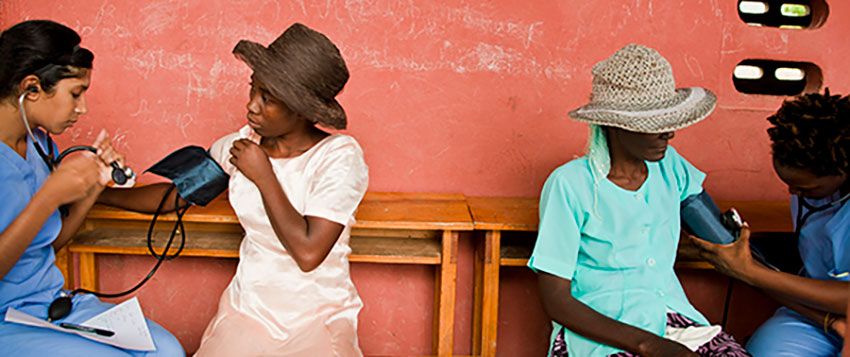 GW medical professionals taking blood pressure readings from two Haitian patients