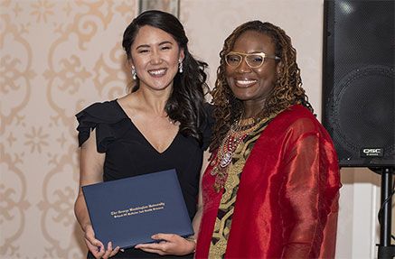 A MD Program award recipient standing with an award next to a woman