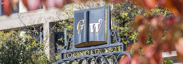 GW symbol on a campus gate overlooking campus