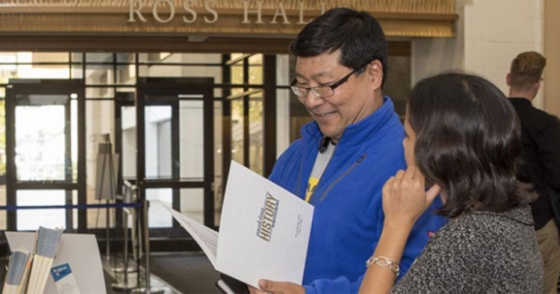 A SMHS alumni reading a folder inside Ross Hall