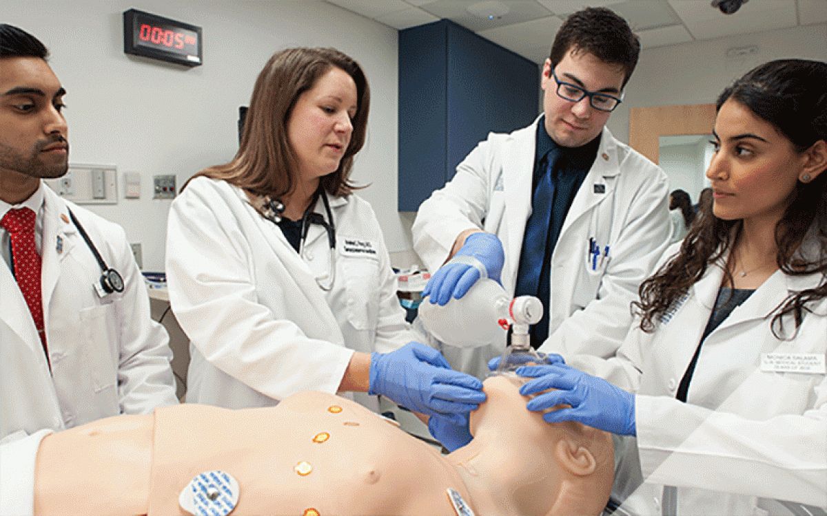 Med students using an ambu bag on a mannequin