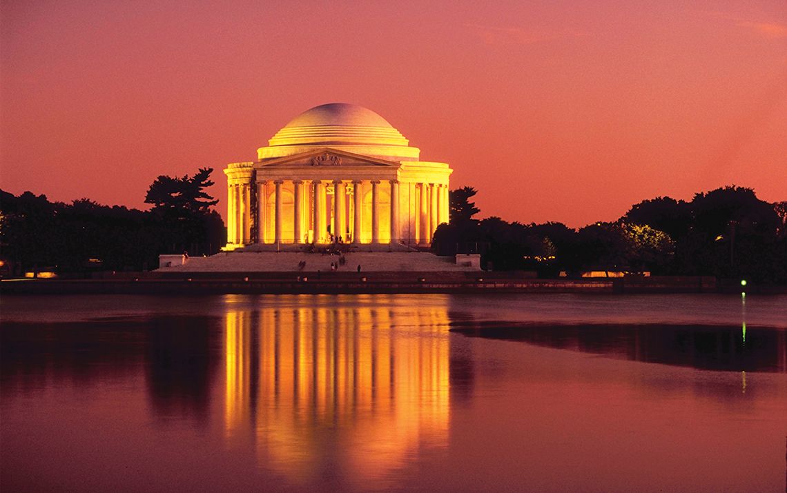 Jefferson memorial lit up with a pink sunset