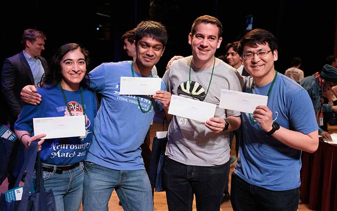 Four students pose with Match Day letters