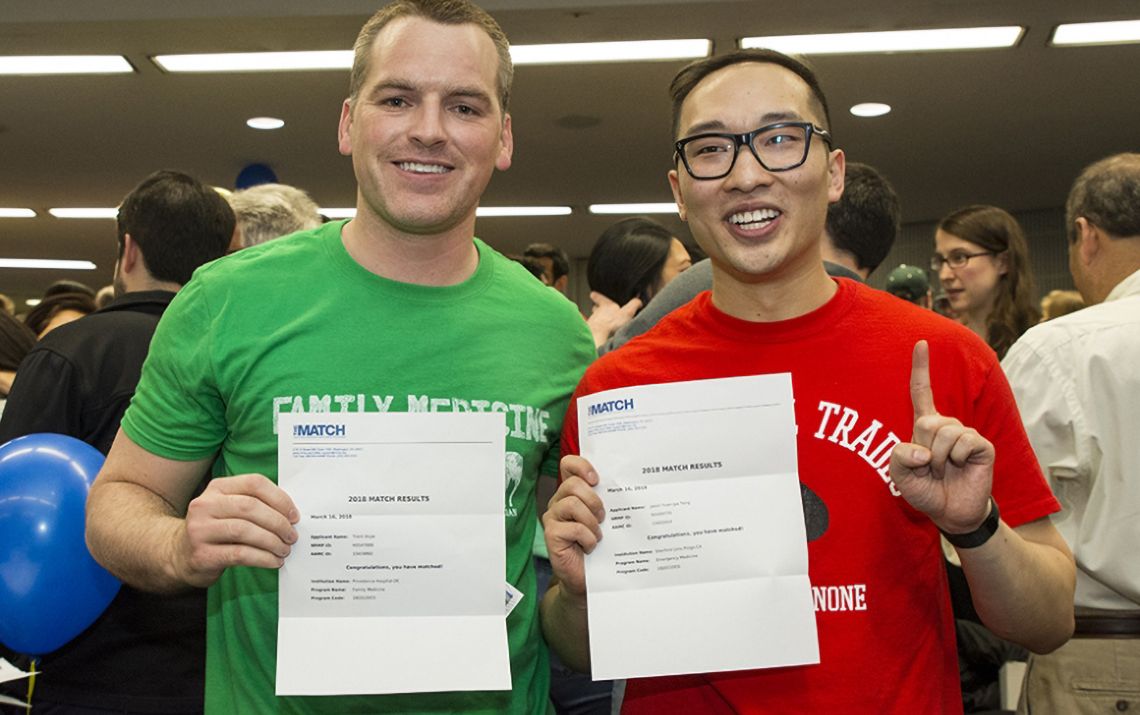 students smiling and holding their match letters