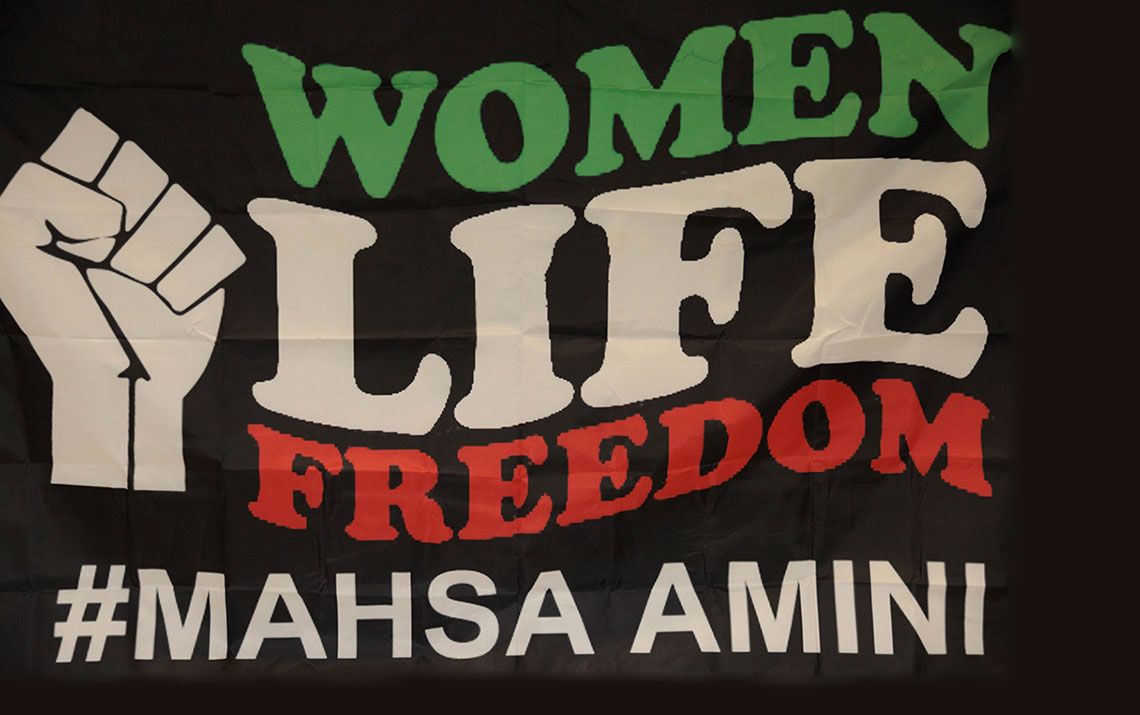 Poster saying Women of Iran slogan, Women, Life, Freedom; Mahsa Amini