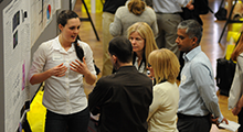 People presenting research posters at Research Day