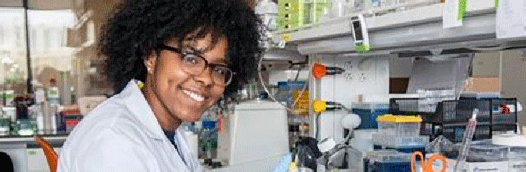 A researcher in a lab smiling