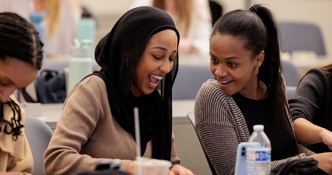Students smile scratching off match to reveal location