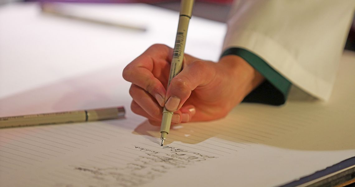 Close up of someone signing the honor code