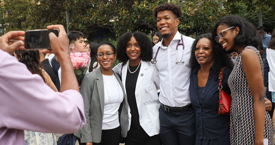 Families pose for photos after white coat