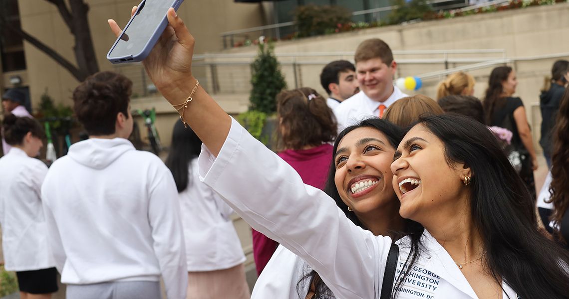 Students pose for selfies after white coat ceremony