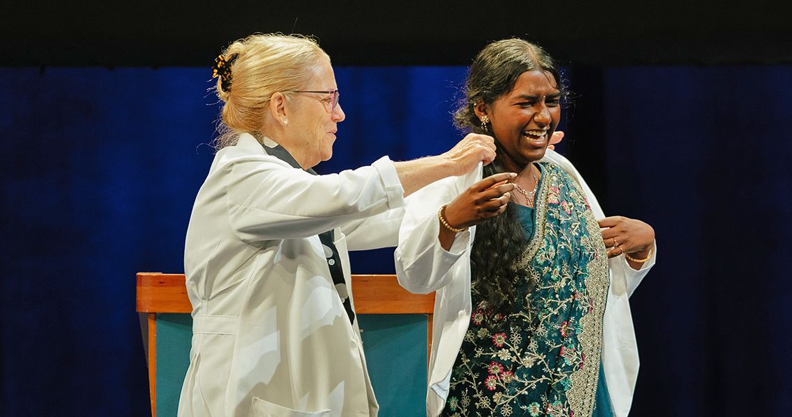 Dean Bas helps MD student into her first white coat