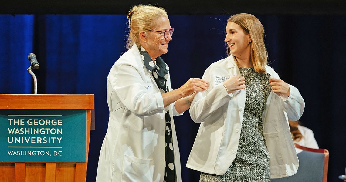 Dean Bas helps MD student into her first white coat