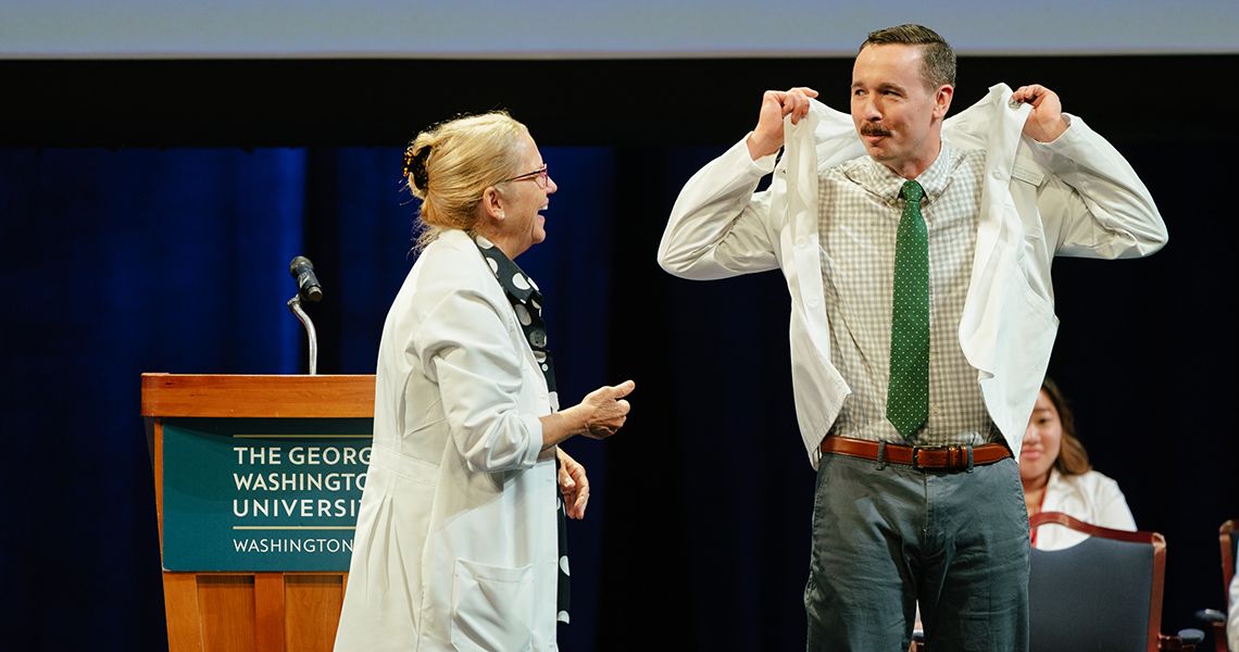 Dean Bas helps MD student into his first white coat