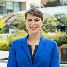 Leigh Frame, PhD, outside Ross Hall in blue jacket