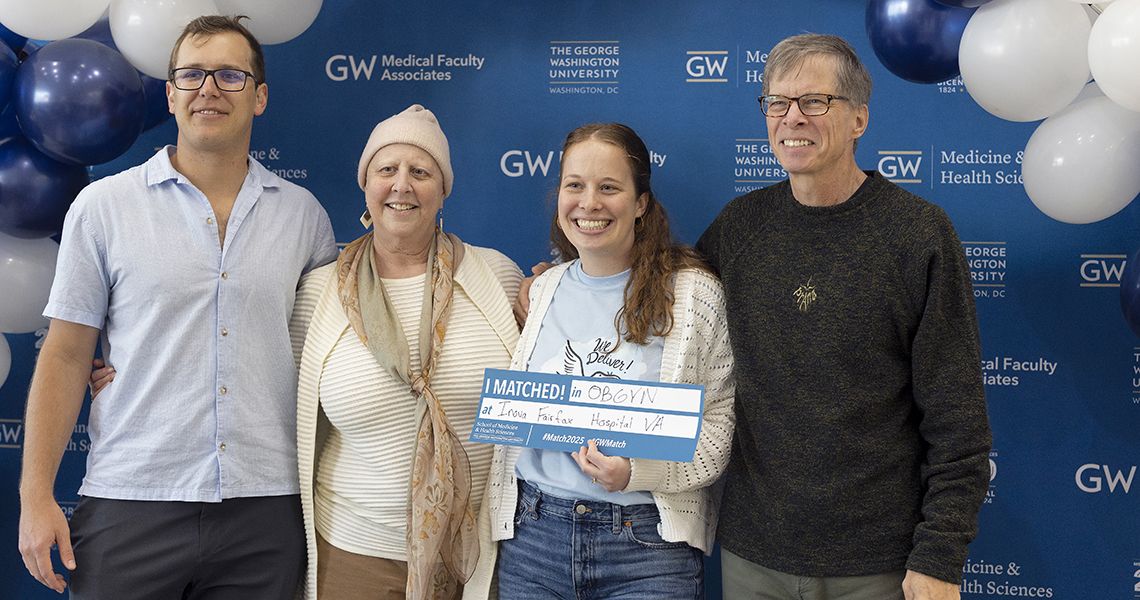 GW SMHS student poses with family