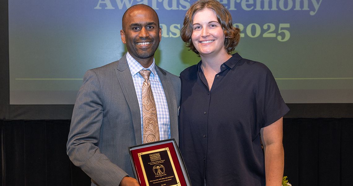Awardee posing with faculty member holding plaque