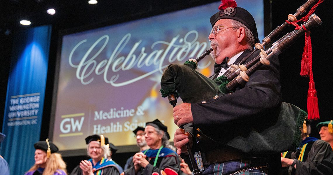 Bagpiper leads the faculty and graduate procession into Lisner Auditorium