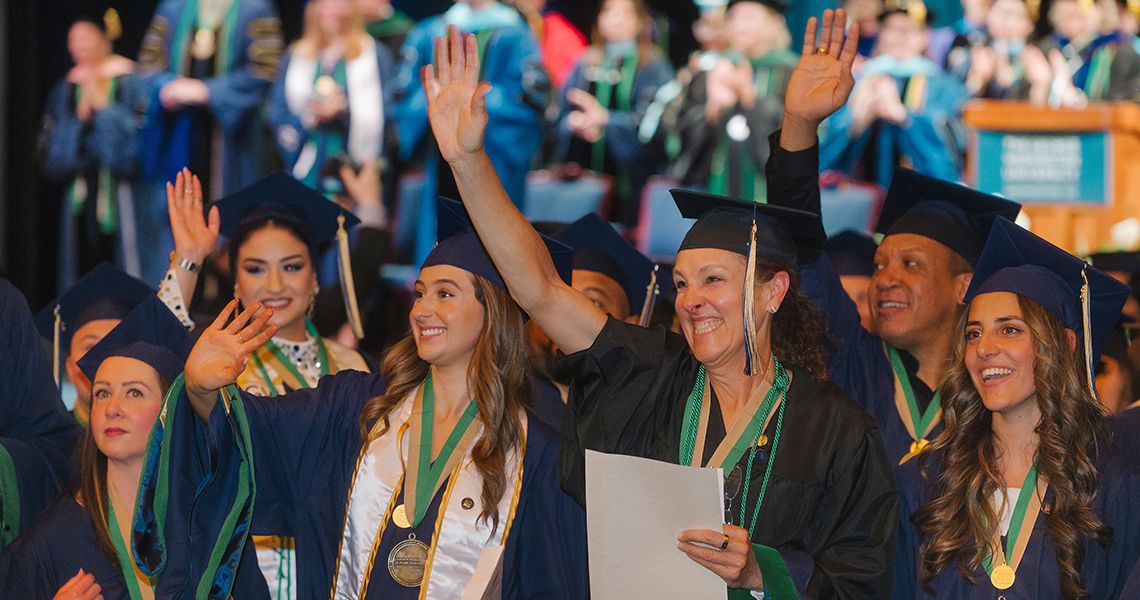 GW SMHS Health Sciences graduates smile and wave at the diploma celebration
