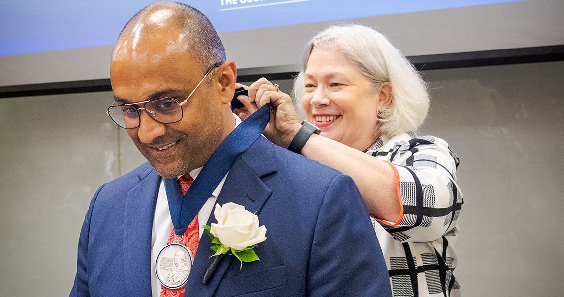 President Granberg puts medal on Dr. Goyal