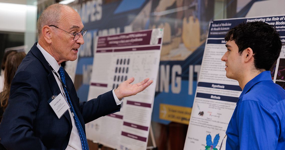 Student presenting research to Robert Miller
