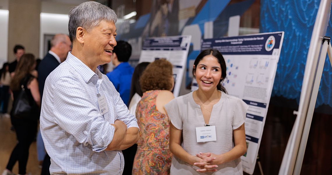 Student presenting research to Ed Seto