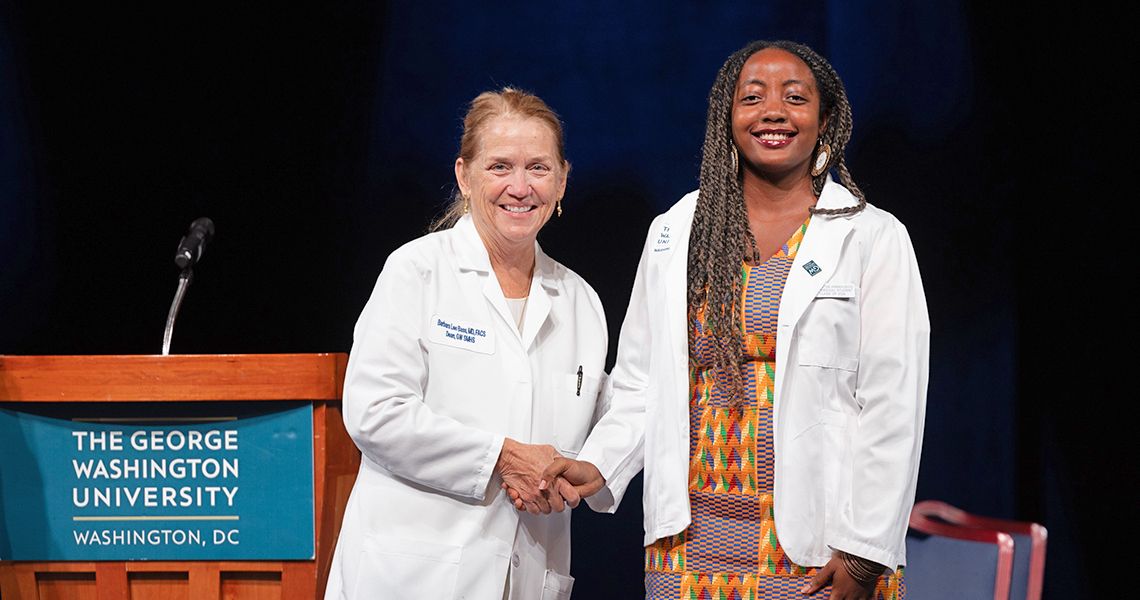 Dean poses with female student at White Coat ceremony