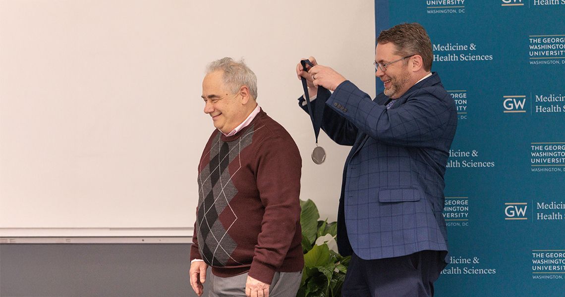 Provost Lach putting a medal on David Mendelowitz 