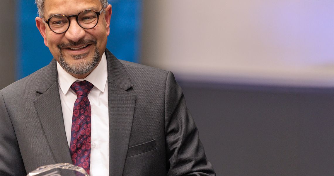 Sanjay Maggirwar smiling at the podium